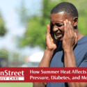 Man outside with his hands on his head due to heat exhaustion. Featured image for How Summer Heat Affects Blood Pressure, Diabetes, and More blog